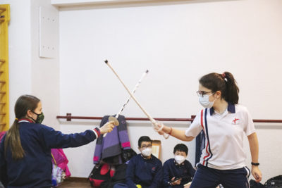Alumnas hacen combate con espadas de material reciclado